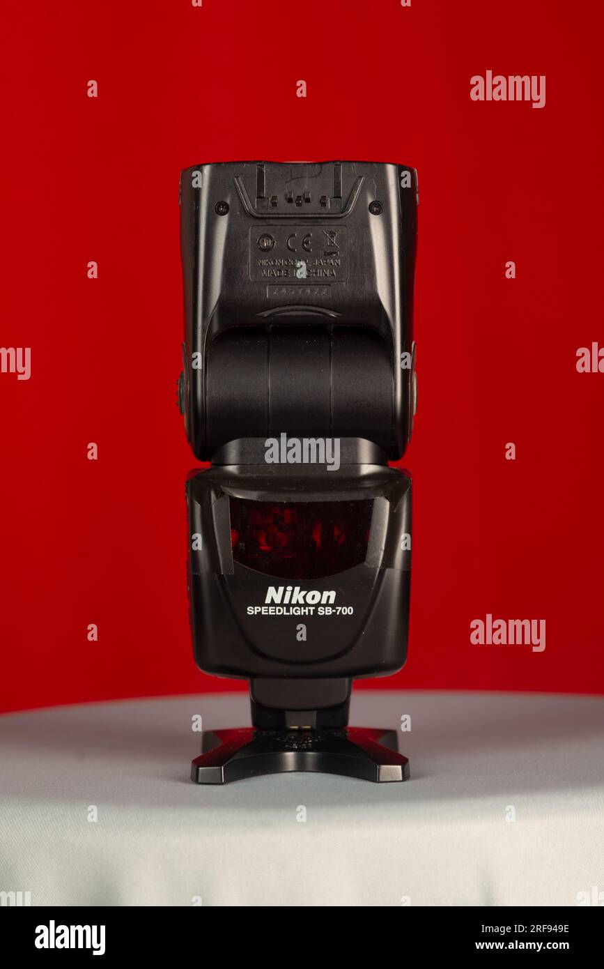 Salvador, Bahia, Brésil - 30 juillet 2023 : un flash de marque Nikon du modèle SB-700 debout sur fond rouge. Banque D'Images