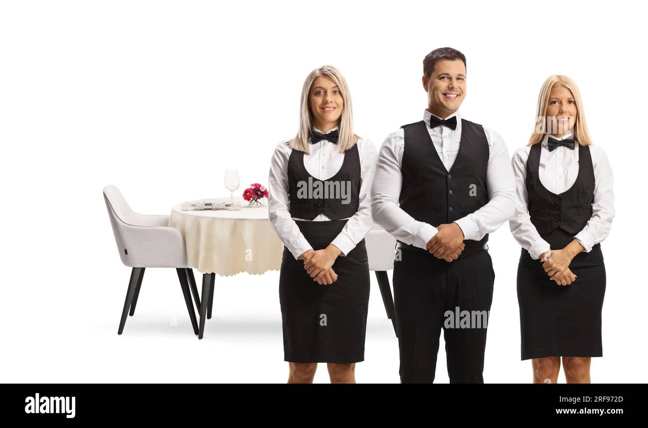 Serveurs en uniformes posant devant une table de restaurant isolé sur fond blanc Banque D'Images