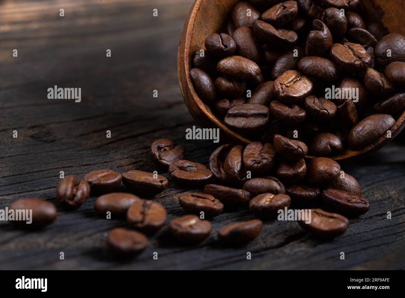 Grains de café dans une cuillère en bois. Banque D'Images