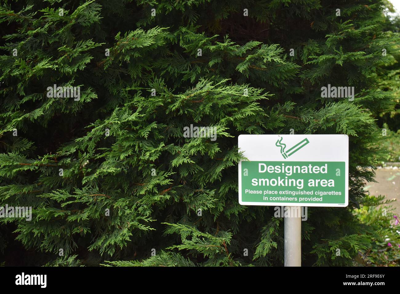 Panneau : « zone fumeurs désignée » à l'extérieur du Milton Keynes Theatre, indiquant où fumer est autorisé, avec espace de copie. Banque D'Images