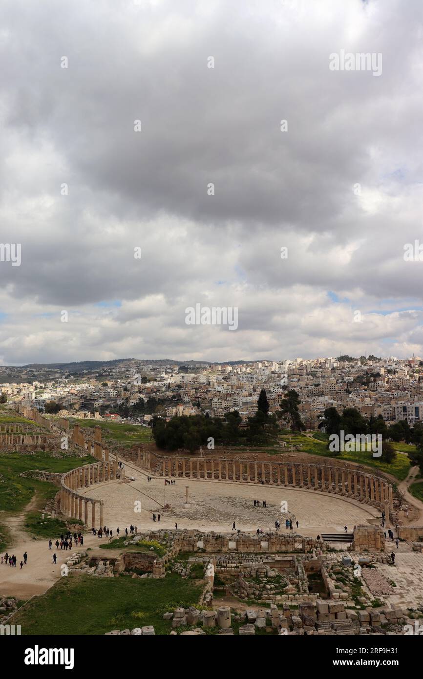 Colonnes du Forum ovale dans l'ancien Jerash, Jordanie (ville de Rome) et nouveaux bâtiments de Jordaniens Banque D'Images