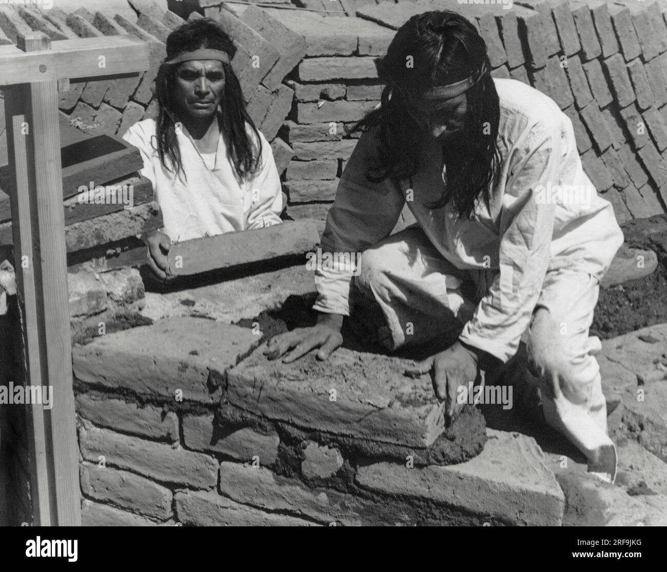 Californie : vers 1930 les padres enseignèrent aux Amérindiens à fabriquer les briques d'adobe utilisées dans la construction des missions. Les cadres de porte et de fenêtre ont été fabriqués par les charpentiers. Des chevilles rondes en bois tenaient les cadres ensemble. Les briques ont été posées autour des parties supérieures et inférieures saillantes des cadres pour les maintenir solidement dans le mur. Les Indiens apprenaient à poser chaque brique soigneusement afin de maintenir les couches de briques de niveau et de former des murs droits. Banque D'Images