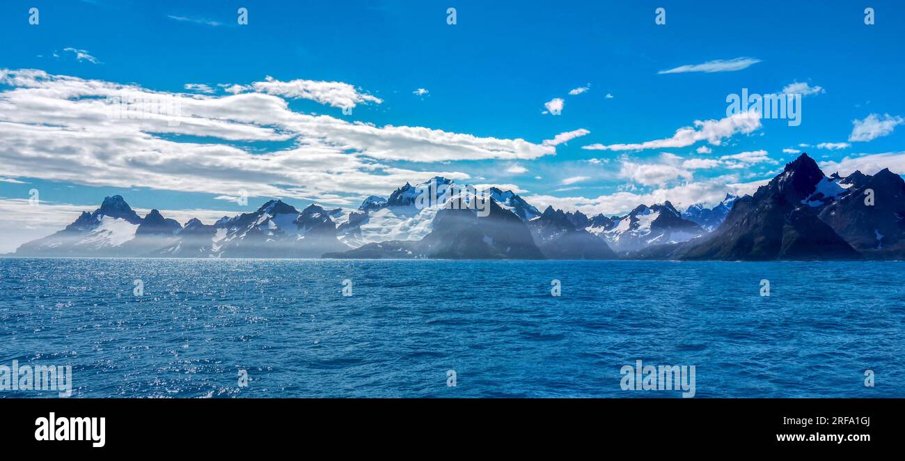 Vue panoramique sur les montagnes déchiquetées et les glaciers le long de la côte sud de l'île de Géorgie du Sud vue de la mer par une journée ensoleillée. Banque D'Images