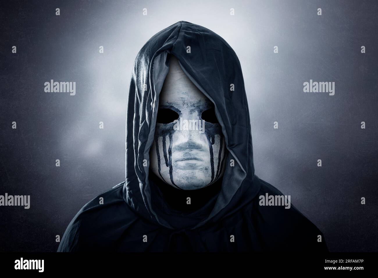 Figurine sinistre avec cape à capuchon sur fond sombre et brumeux Banque D'Images