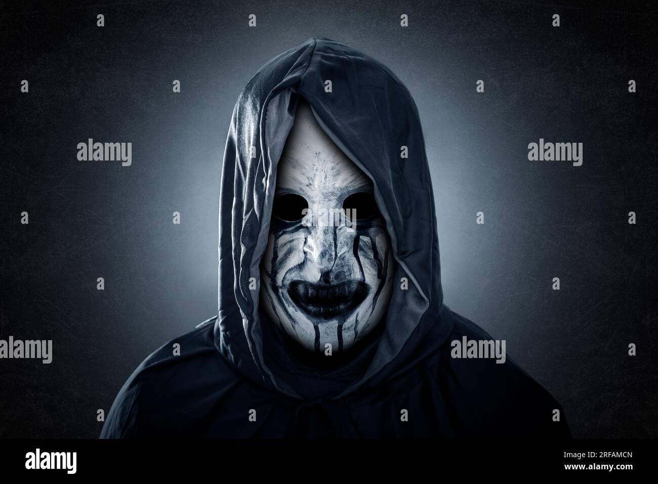 Figurine sinistre avec cape à capuchon sur fond sombre et brumeux Banque D'Images