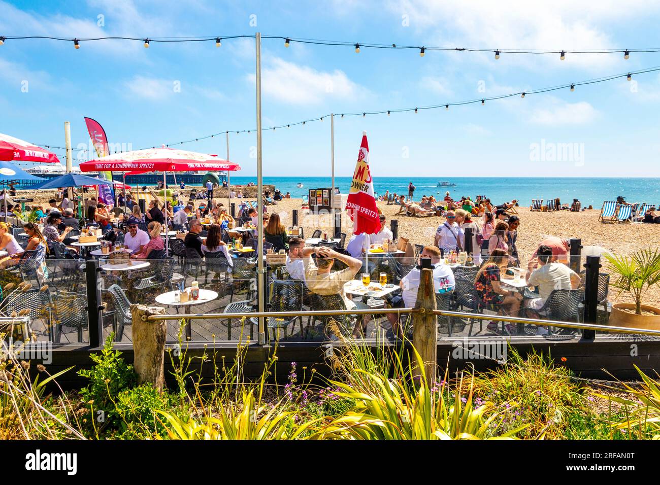 Les gens dînent en plein air au Ohso social Beach Bar and Restaurant par une journée ensoleillée, Brighton, East Sussex, Angleterre Banque D'Images