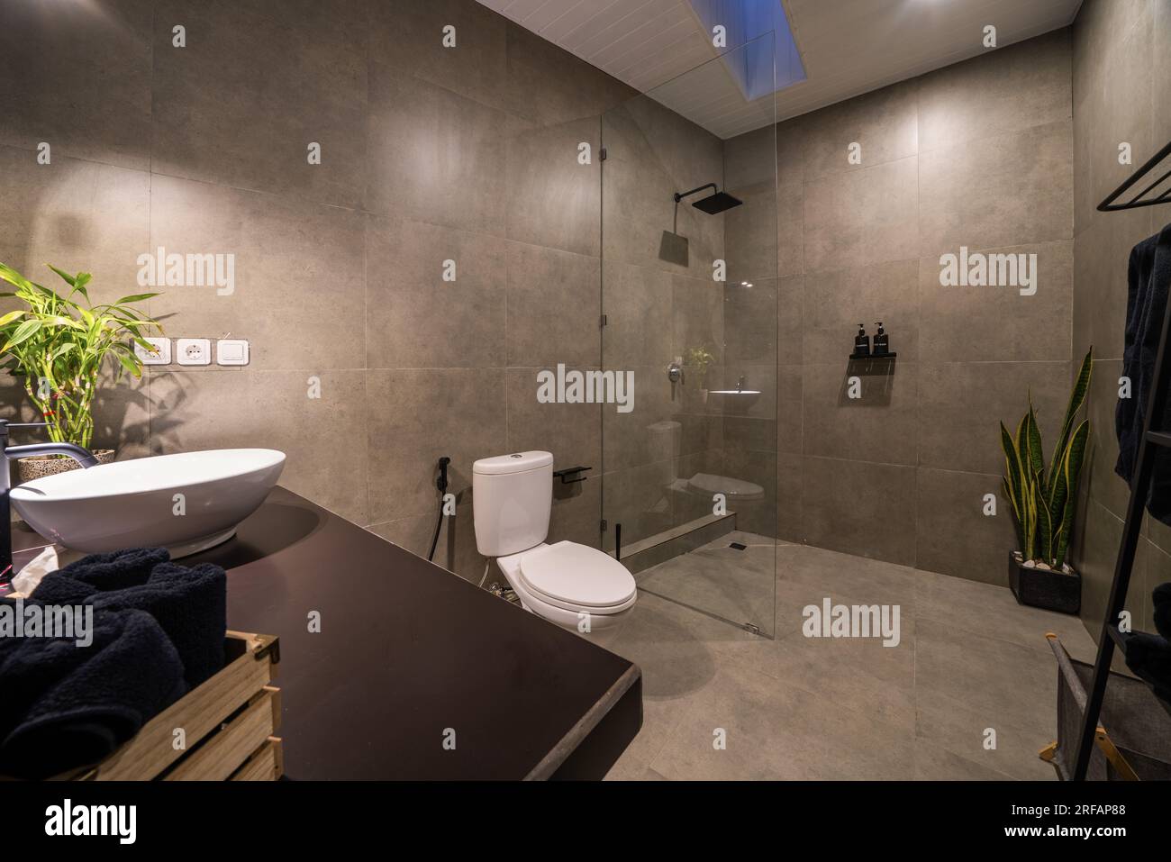 Salle de bains luxueuse avec béton poli sur les murs et carrelage céramique sur le sol. Salle de bains moderne avec murs cimentés. Banque D'Images