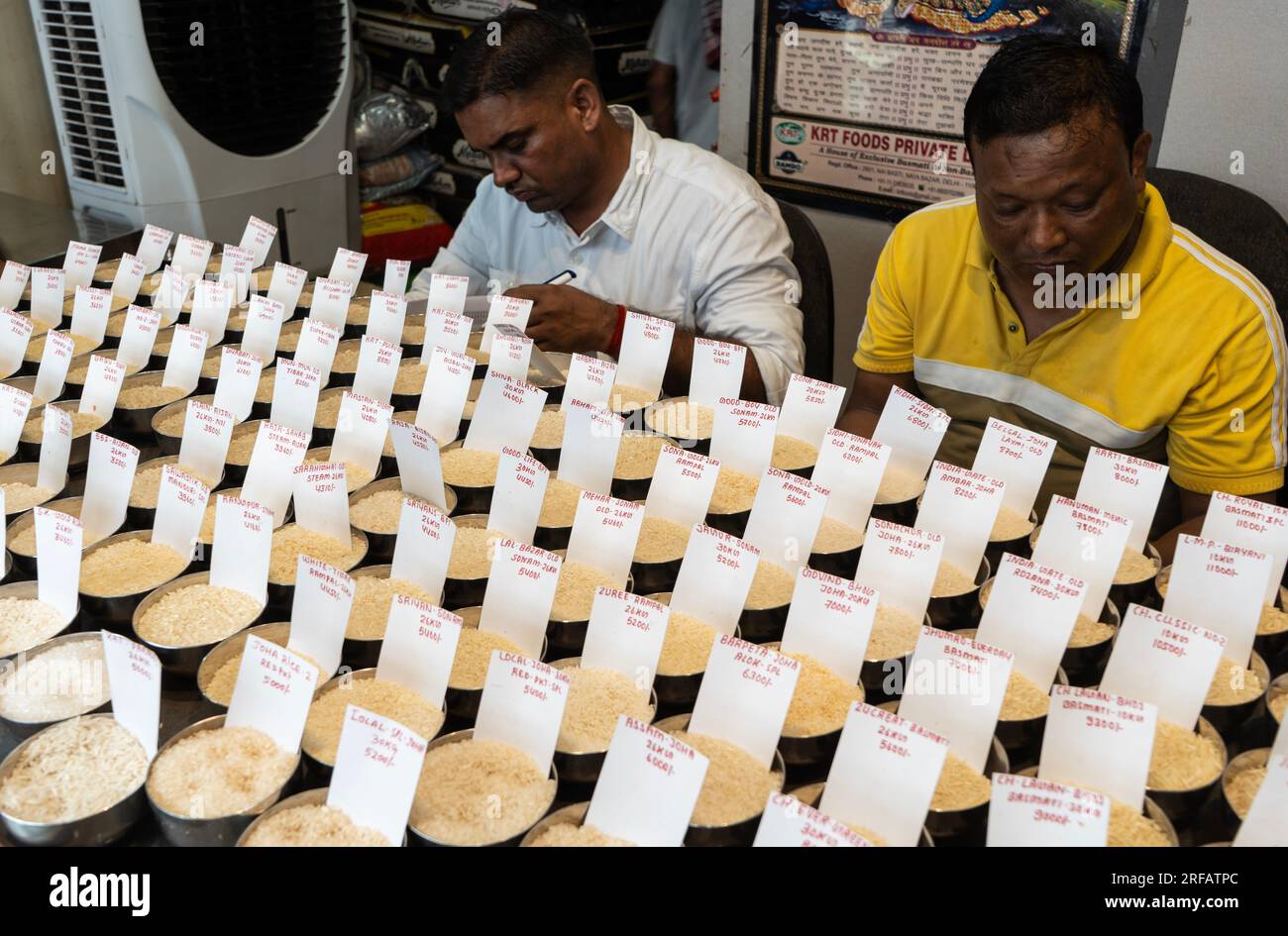 Le négociant en riz expose une variété d'échantillons de riz dans un magasin de gros, à Guwahati, Assam, en Inde, le 2 août 2023. Pénuries de riz non basmati causées par les pluies et la sécheresse en Inde, le gouvernement indien interdit les exportations de riz pour assurer l'approvisionnement intérieur. Crédit : David Talukdar/Alamy Live News Banque D'Images