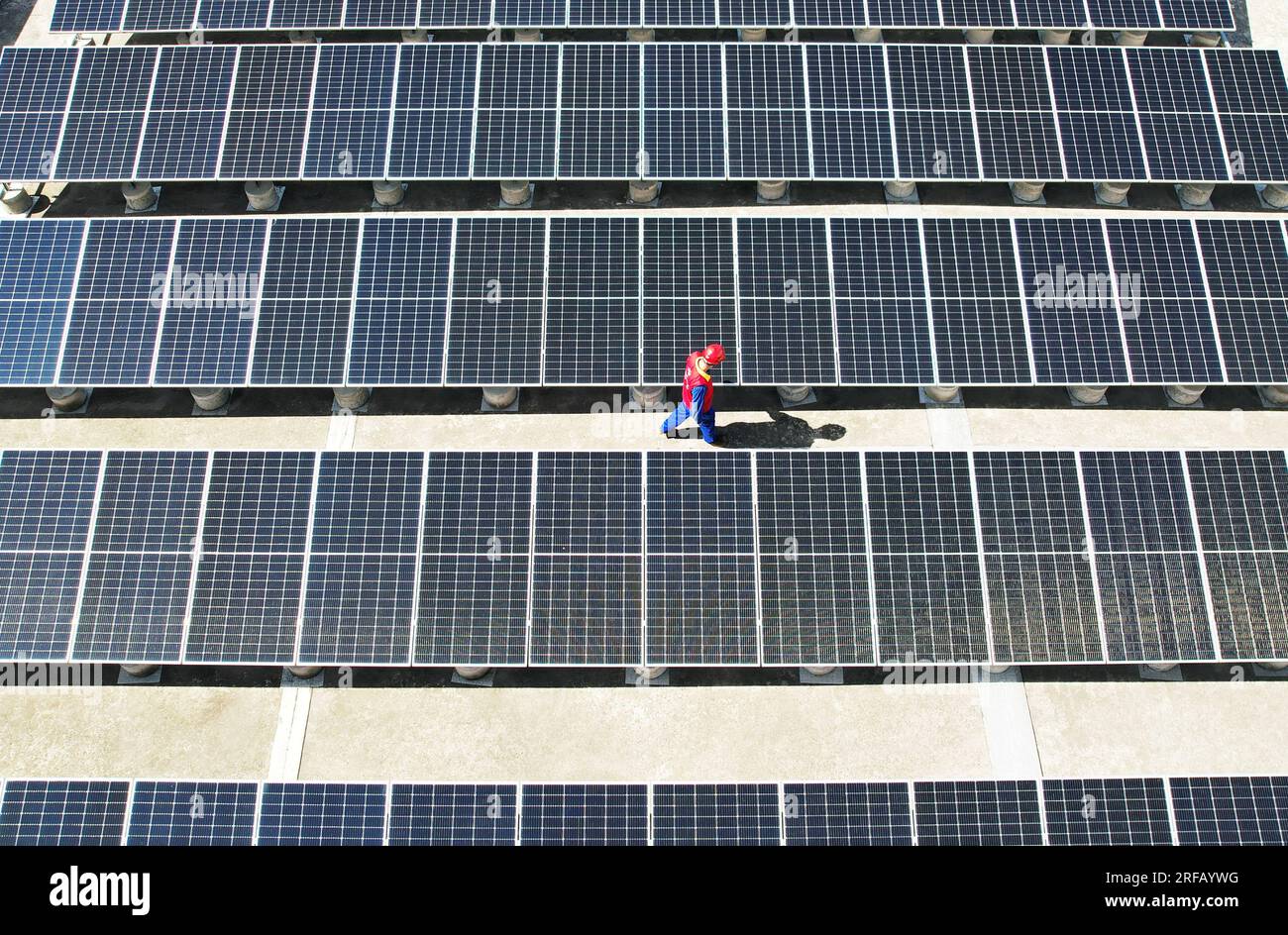 HANGZHOU, CHINE - 2 AOÛT 2023 - des employés d'une société d'alimentation électrique vérifient les installations de production d'énergie photovoltaïque sur le toit d'une école primaire Banque D'Images