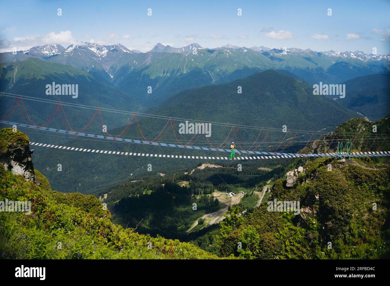 Femme courrant marchant sur le pont suspendu de corde dans les montagnes du caucase, Russie. Photo de haute qualité Banque D'Images