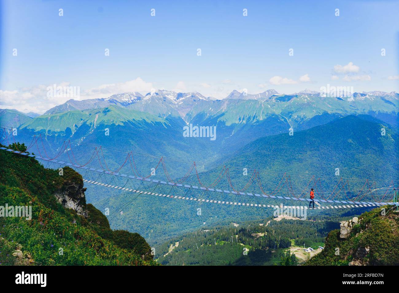 Homme marchant sur le pont suspendu de corde dans les montagnes du caucase, Russie. Photo de haute qualité Banque D'Images