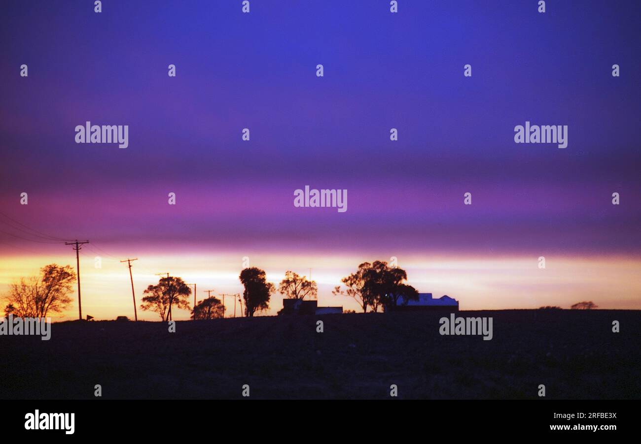 silhouette des bâtiments agricoles agaist un coucher de soleil coloré Banque D'Images