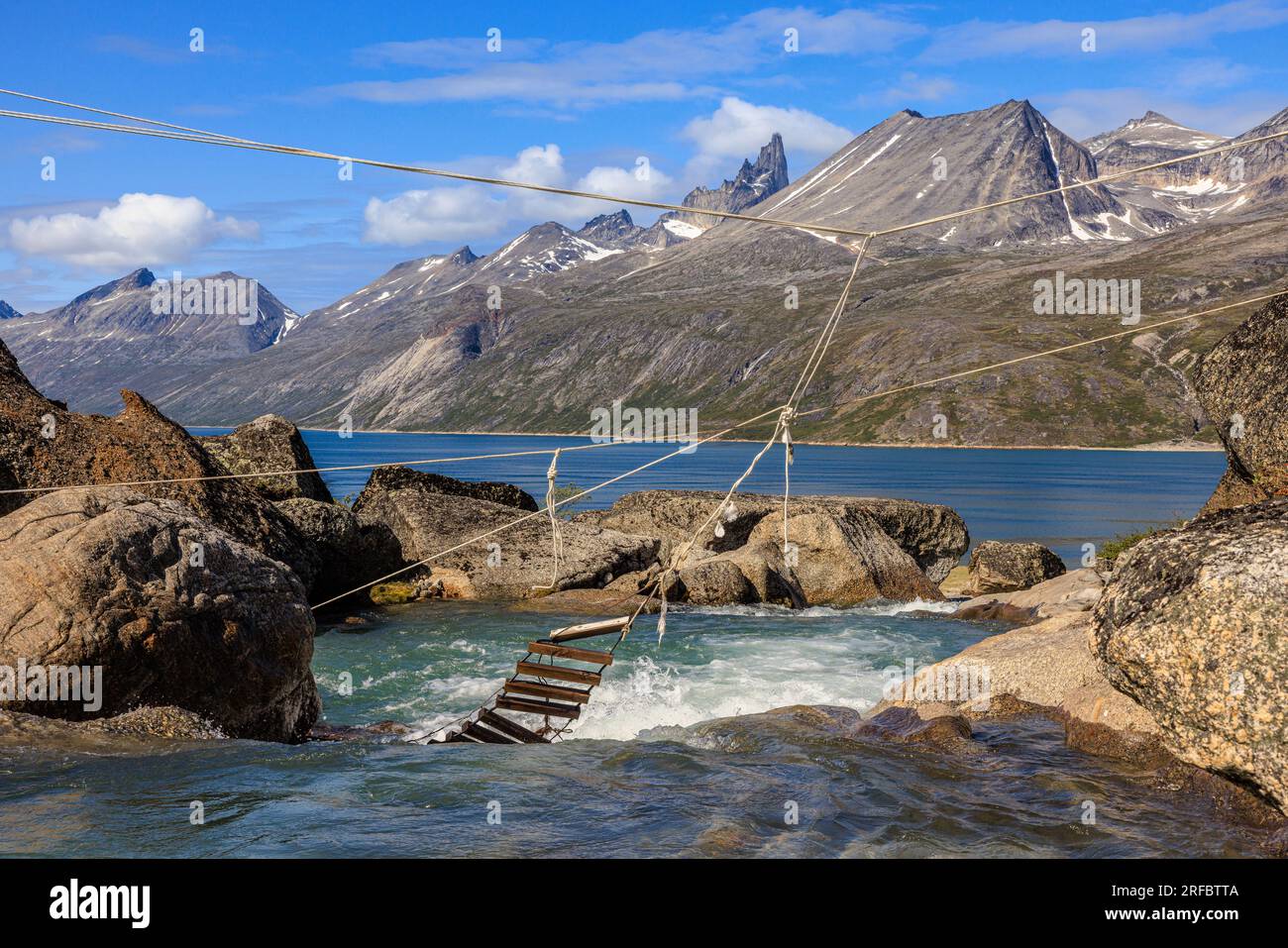 un pont en échelle de corde cassé pend dans un ruisseau qui coule dans le paysage spectaculaire du fjord tasermiut groenland Banque D'Images