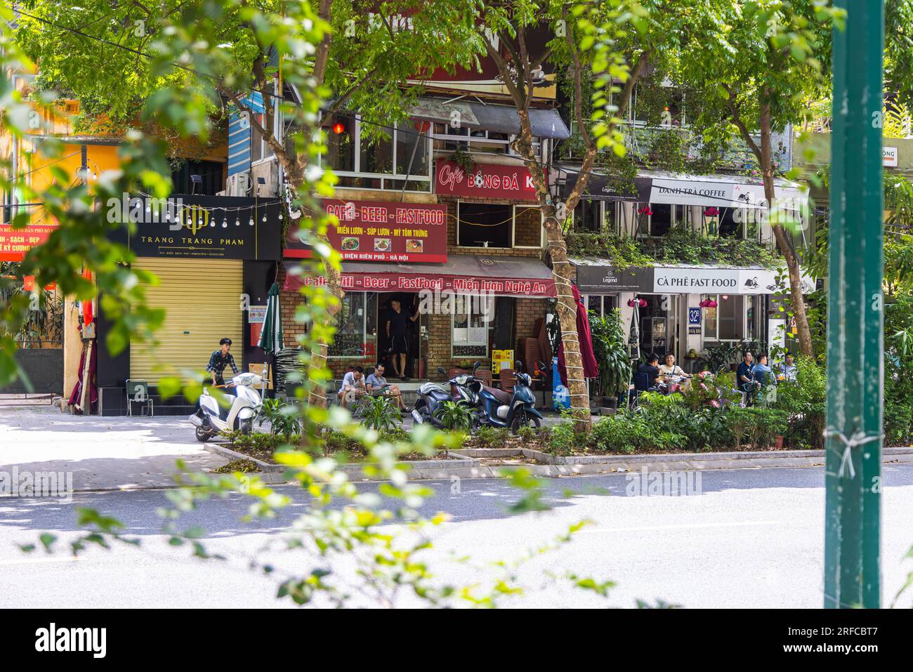 Hanoi, Vietnam - 28 mai 2023 : une rue vibrante bourdonne de vie alors que les habitants se rassemblent dans un restaurant animé au bord de la route. Ils sont assis sur des tabourets bas, partageant la rire Banque D'Images