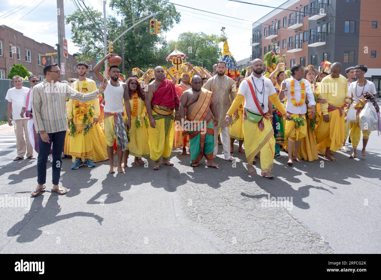 Un groupe de fervents hindous vêtus de vêtements ethniques défilent de leur temple dans ozone Park à Arya Spiritual Grounds pour un service de marche du feu. Banque D'Images