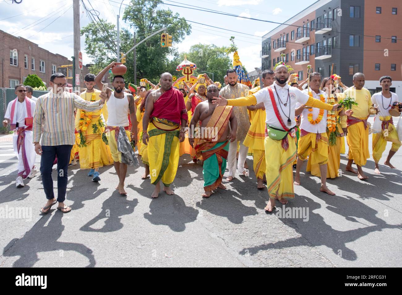 Un groupe de fervents hindous vêtus de vêtements ethniques défilent de leur temple dans ozone Park à Arya Spiritual Grounds pour un service de marche du feu. Banque D'Images