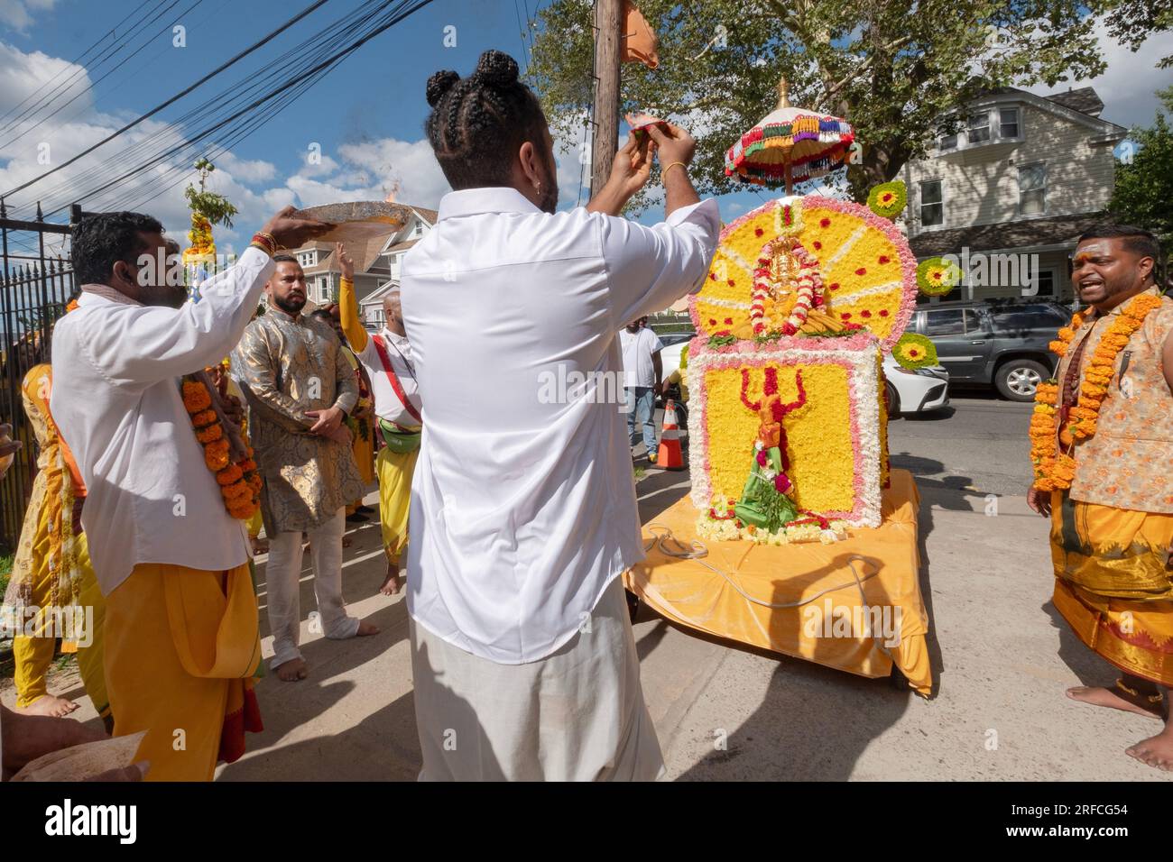 Avant la marche du feu Thimithi, un autel arrive et les dévots hindous le saluent avec le rituel arti d'agiter une flamme en cercle. Jamaïque, Queens, NY Banque D'Images