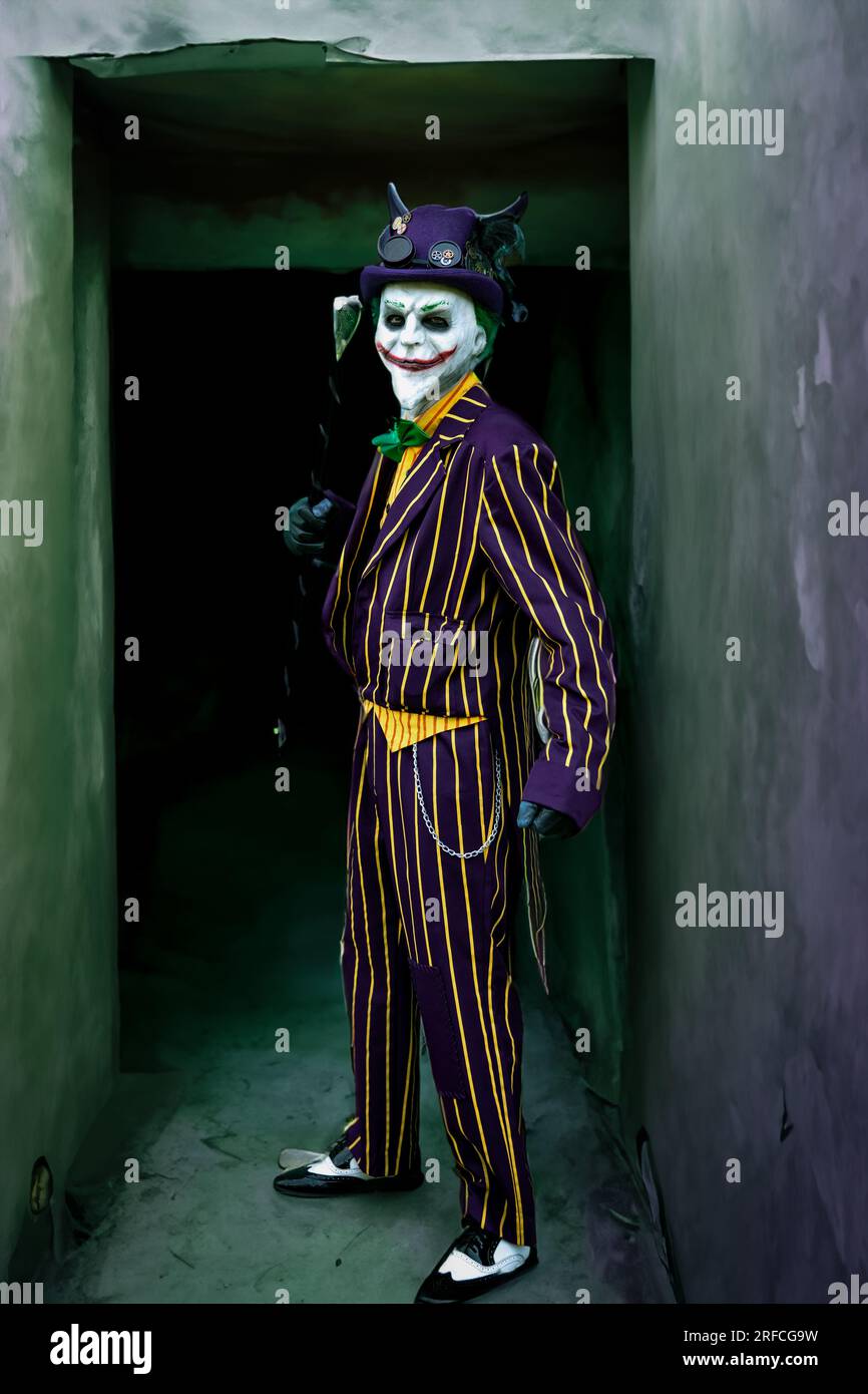HARROGATE, ROYAUME-UNI - 3 JUIN 2023. Un cosplayer masculin habillé comme le joker des films de batman avec masque et fond grunge Banque D'Images