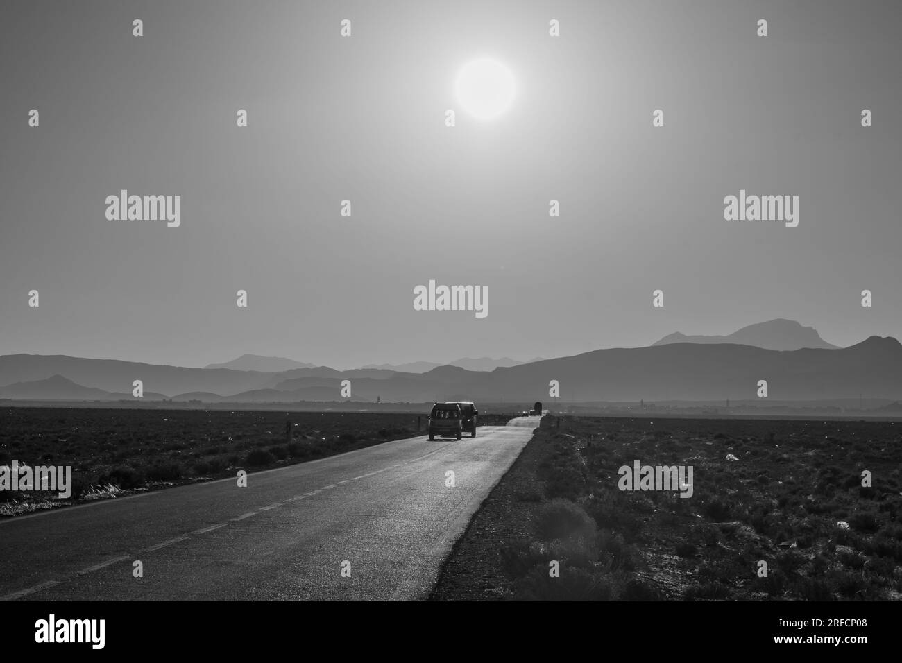 Vue sur une route désertique, avec les montagnes de l'Atlas en arrière-plan. Maroc central Banque D'Images