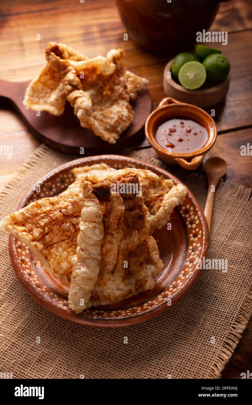 Chicharron. La croûte de porc frite et croustillante est composée de morceaux de peau de porc frite et aérée, d'ingrédients mexicains traditionnels ou d'en-cas servis avec du jus de lime et du ho rouge Banque D'Images