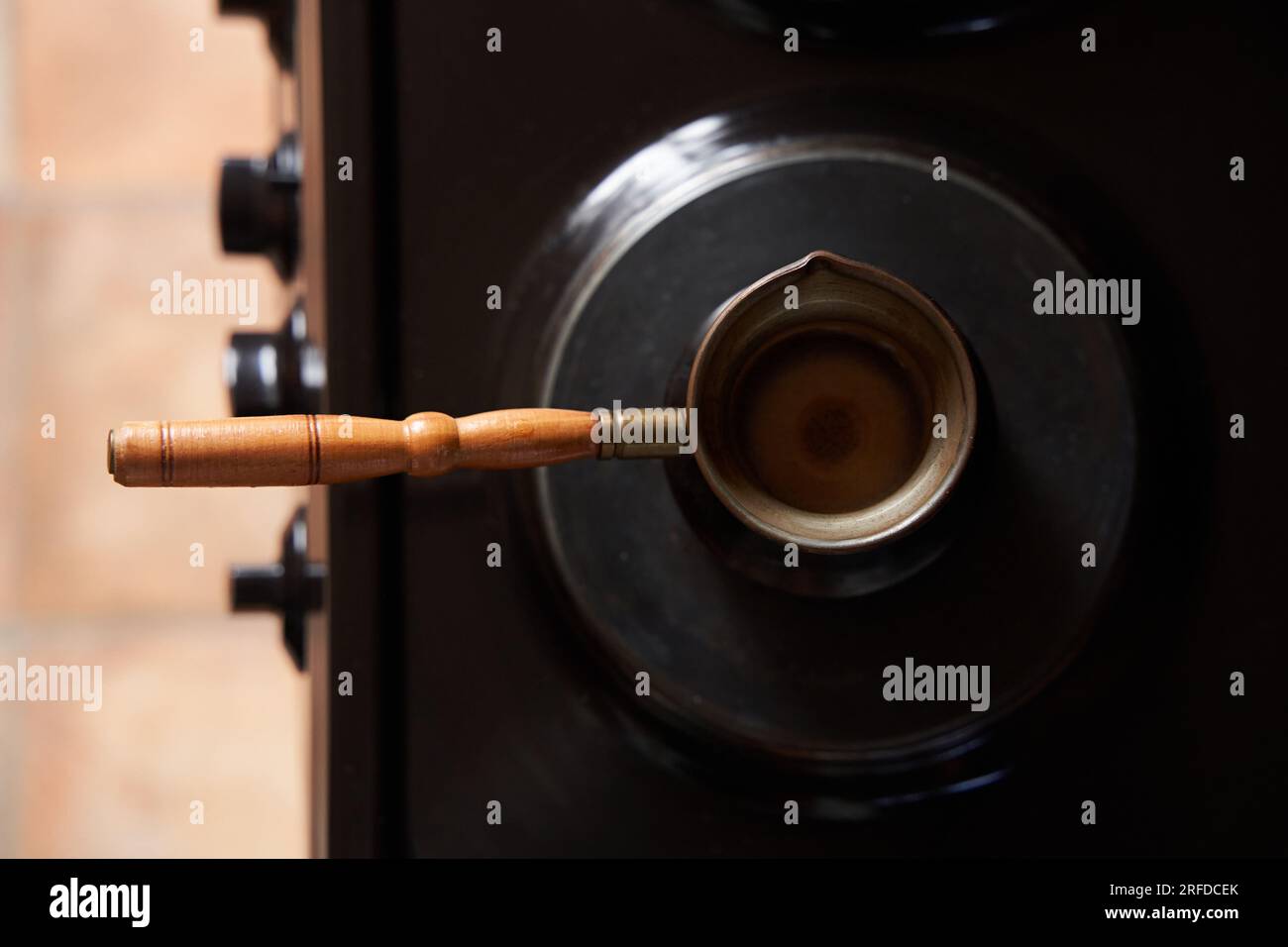 Un homme préparant du café noir sur une cuisinière électrique. Préparez du café dans une cafetière turque. Banque D'Images