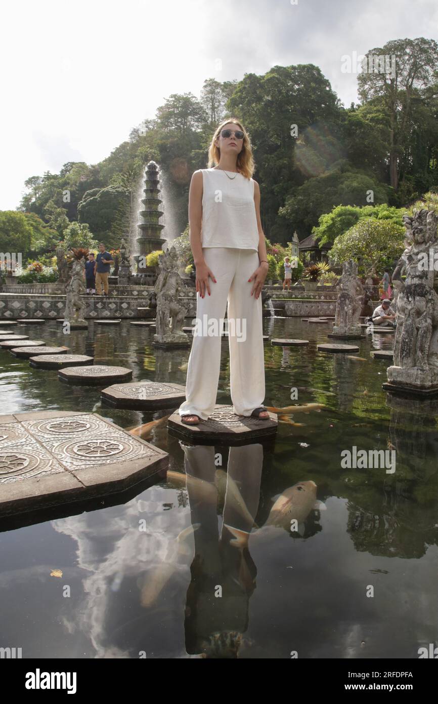 Femme touristique à la mode explorant Balinese Royal Water Palace Tirta Gangga, vacances d'été sur l'île de Bali Banque D'Images