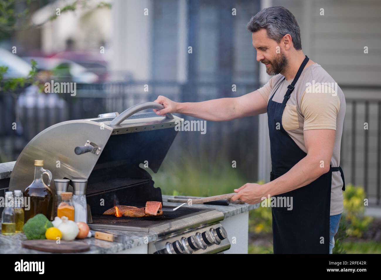 Maître Barbecue Homme Hispanique D'âge Moyen En Tablier Pour Rôtir Au  Barbecue Et Griller Des Aliments Homme Tenir C