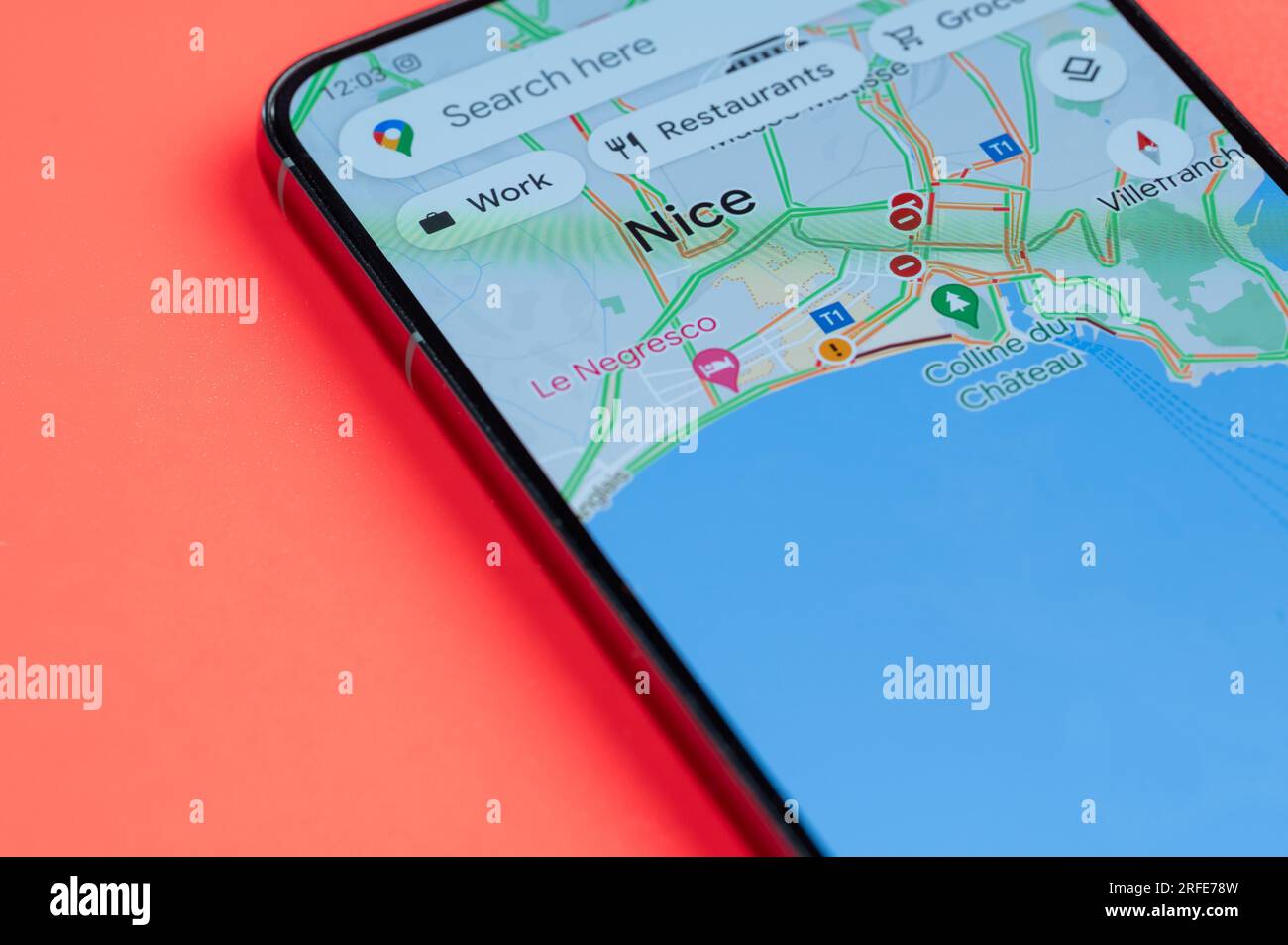 New York, États-Unis - 21 juillet 2023 : faire le meilleur itinéraire à travers les embouteillages à Nice sur écran smartphone vue rapprochée avec fond rouge Banque D'Images