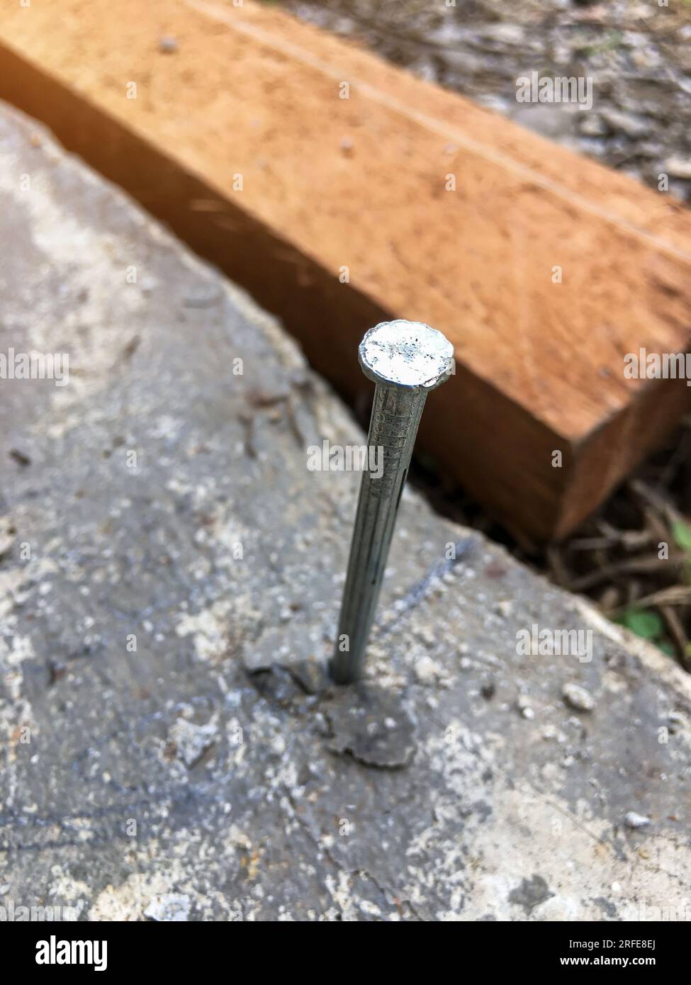 Clous de béton qui sont enfoncés dans le plancher de ciment pour attacher des cordes qui seront utilisés pour trouver la largeur et la longueur de la zone à utiliser dans la construction b Banque D'Images