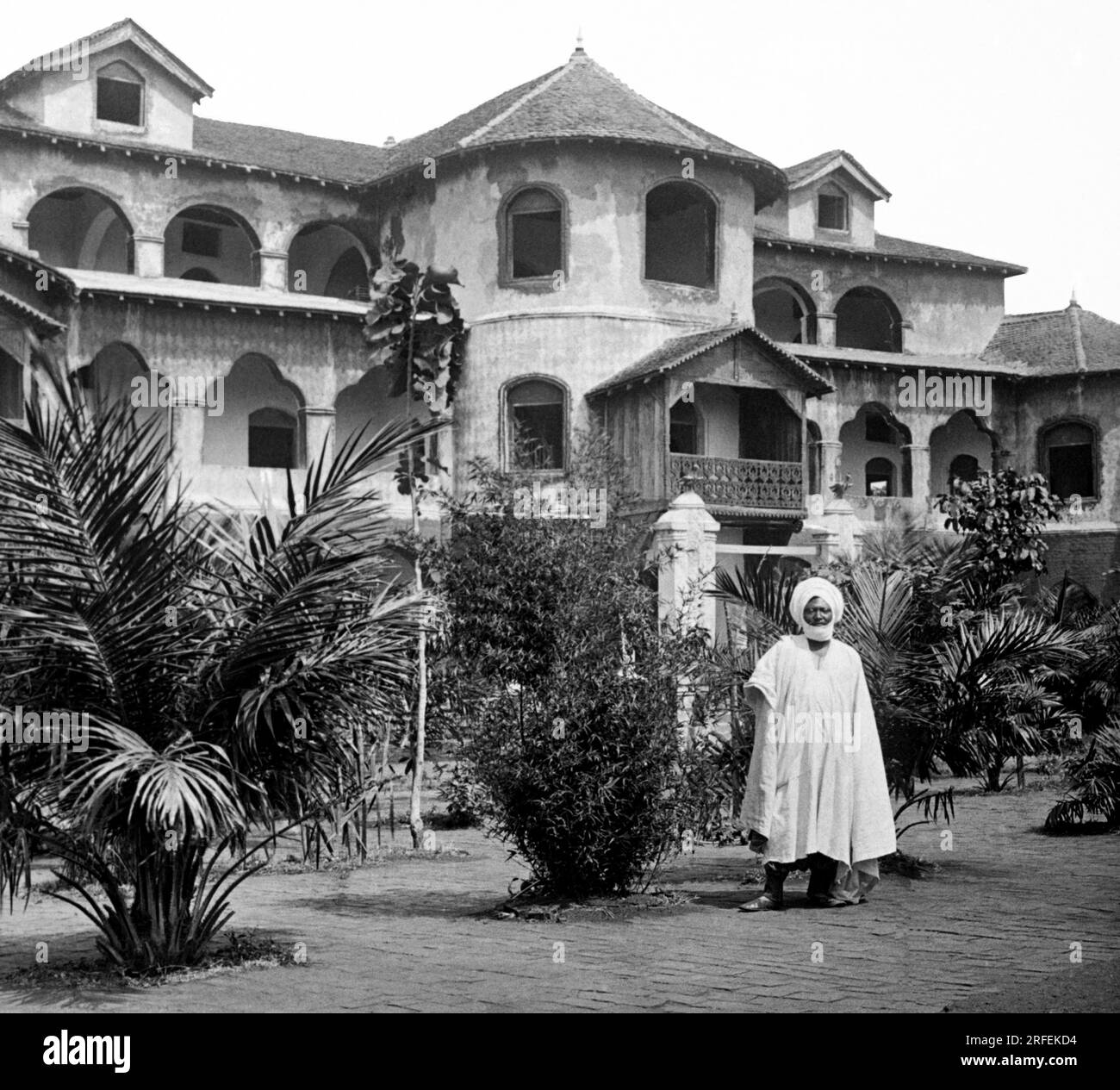 Le palais royal a Foumban (Cameroun), construit en 1917, avec le roi Njoya ( 1876-1933) se trouvant dans le jardin. Photographie Debut XXeme siecle. Banque D'Images