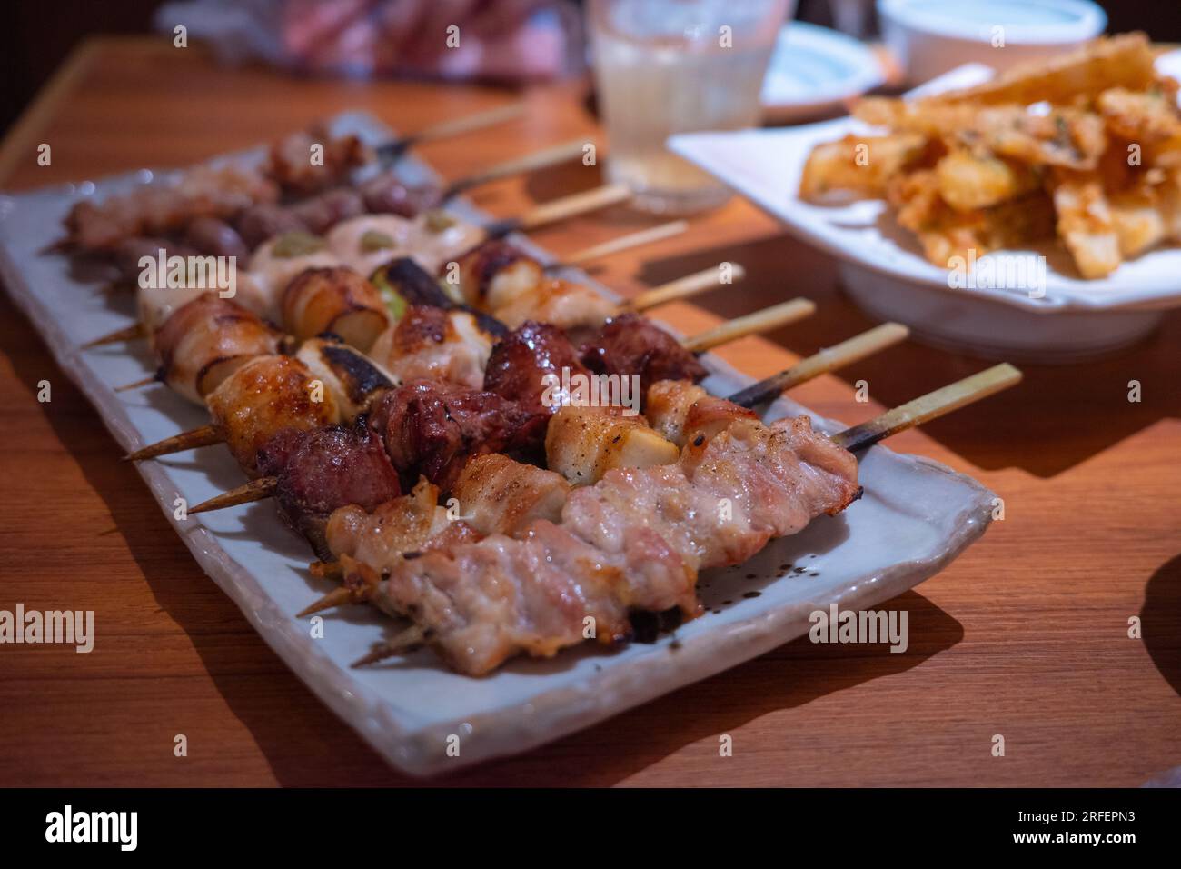 Les brochettes de filet de poulet grillé comprennent des rognons, du foie et de la peau servis avec du bacon et de l'oignon japonais. Banque D'Images