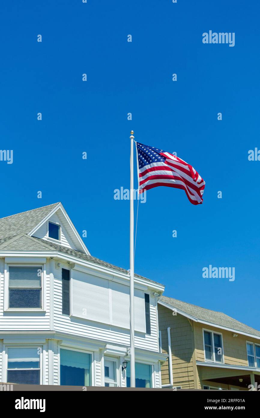 États-Unis, Maine, Wells Beach, drapeau américain devant une belle maison de plage blanche Banque D'Images
