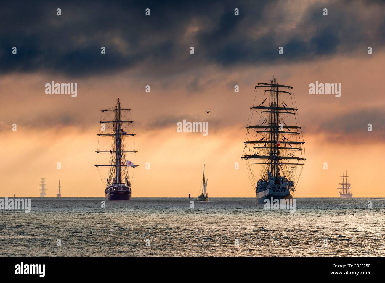 France, Calvados, Honfleur, Armada 2023, Grand Parade, Les navires Dar Mlodziezy, Thalassa, le Français, Bima Suci et Etoile Molène naviguent au soleil couchant et au ciel orageux Banque D'Images