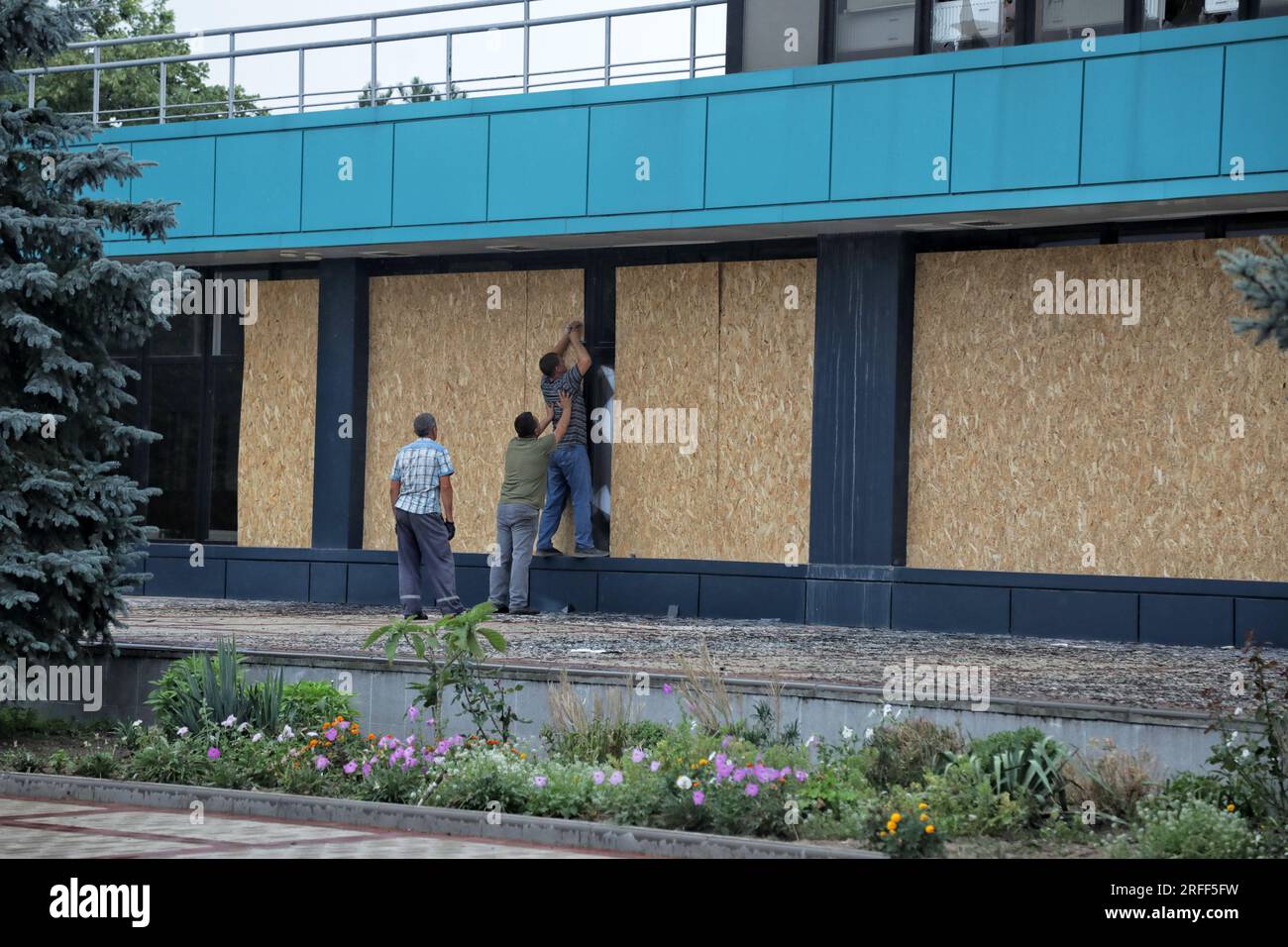 Non exclusive : IZMAIL, UKRAINE - 2 AOÛT 2023 - les hommes scellent les fenêtres avec des planches dans le bâtiment du terminal maritime endommagé dans le drone russe att Banque D'Images