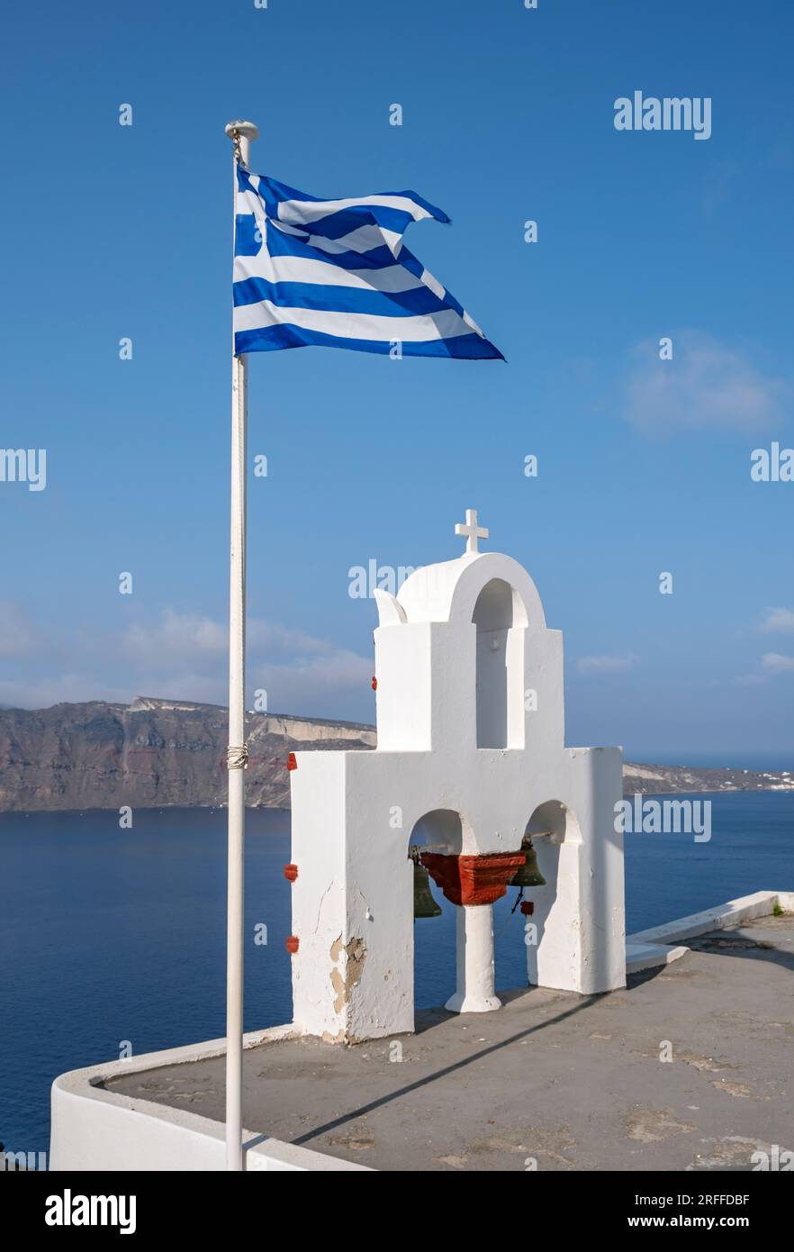 Beffroi blanchi à la chaux et drapeau national grec, IA (Oia), Santorin, Grèce Banque D'Images