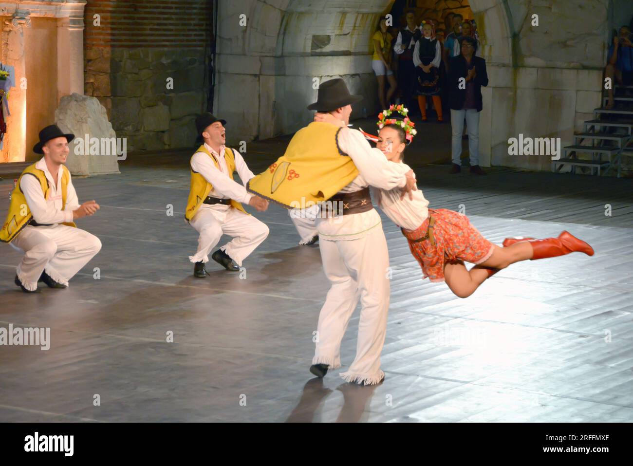 Un groupe de danseurs de la République de Serbie en costumes colorés exécutent une danse traditionnelle au XXI Festival International de folklore à anci Banque D'Images