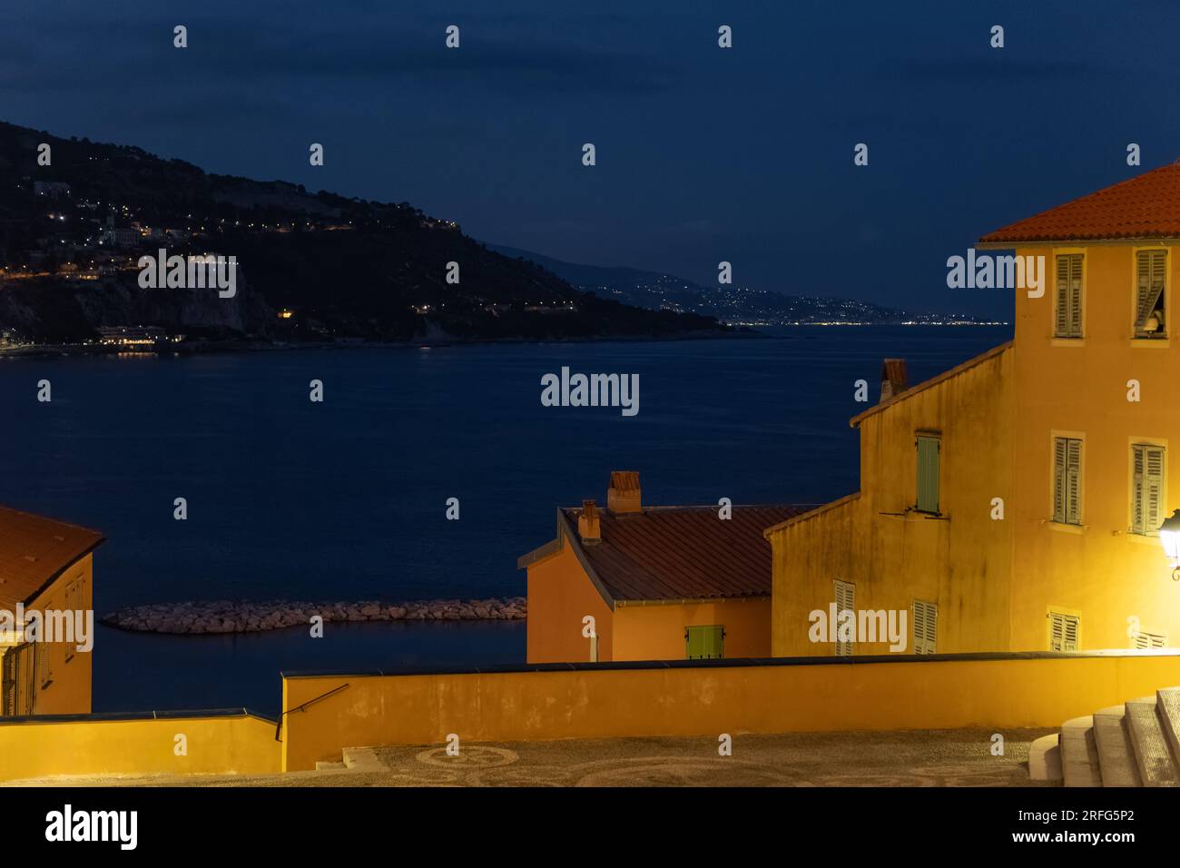 Vue nocturne de Menton (Côte d'Azur) vers la mer Méditerranée. Banque D'Images