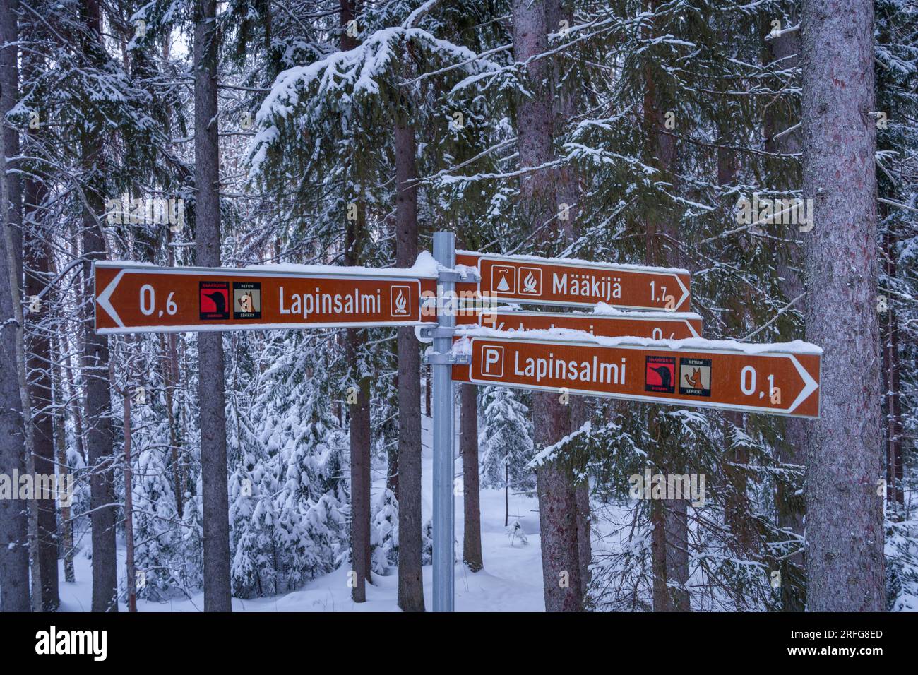 Panneau directionnel dans le parc national de Repovesi en hiver. Affichage de la distance par rapport aux différents sites de feux de camp. Kouvola, Finlande. 6 mars 2023. Banque D'Images