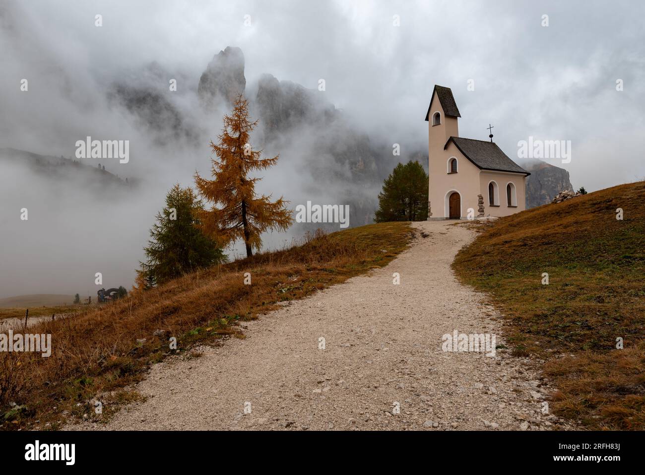 Église de cappella di san Maurizio. Passo gardena passe dans les Dolomites Tyrol du Sud Italie au début de l'automne avec du brouillard couvrant les montagnes de dolomie. Banque D'Images