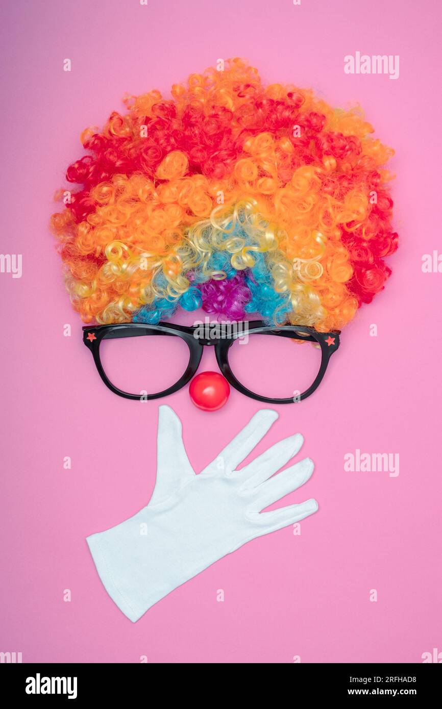 Funny Party concept visage surpris formé avec des gants. Rainbow Clown Wig Set avec lunettes et nez de clown rouge comme un visage, Fluffy afro synthétique Cospl Banque D'Images