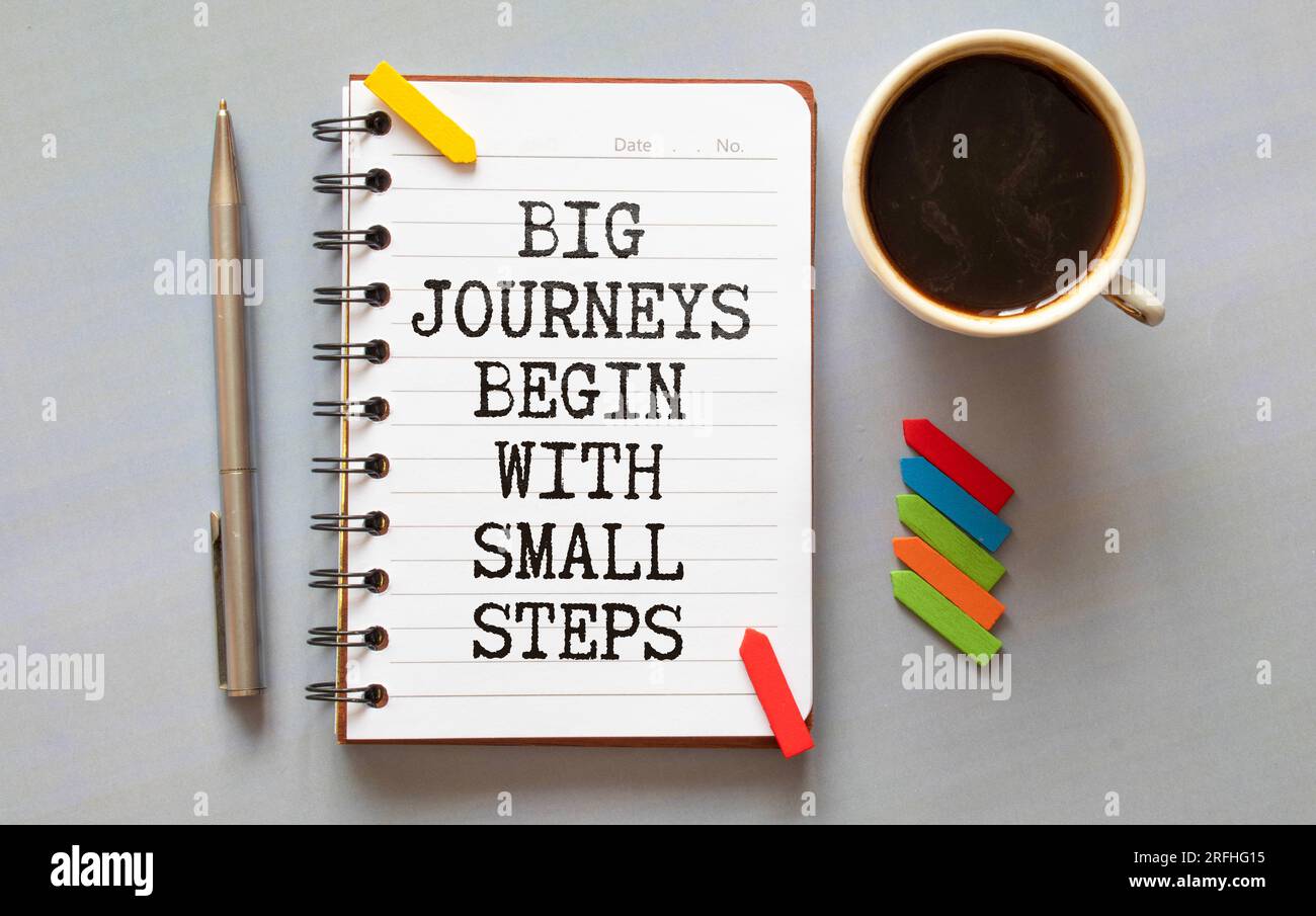 Concept commercial. Carnet de notes avec texte Grands voyages commencer par de petites étapes feuille de papier blanc pour les notes, calculatrice, lunettes, crayon, stylo, dans le whit Banque D'Images