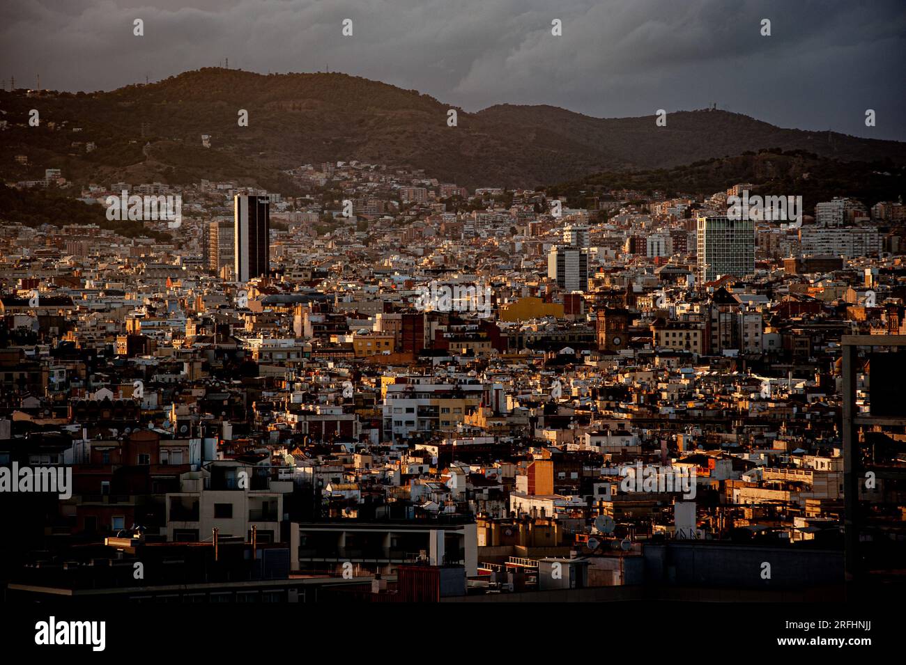 Vue aérienne de la ville de Barcelone avec des toits urbains denses et les collines environnantes sous un ciel nuageux. Banque D'Images