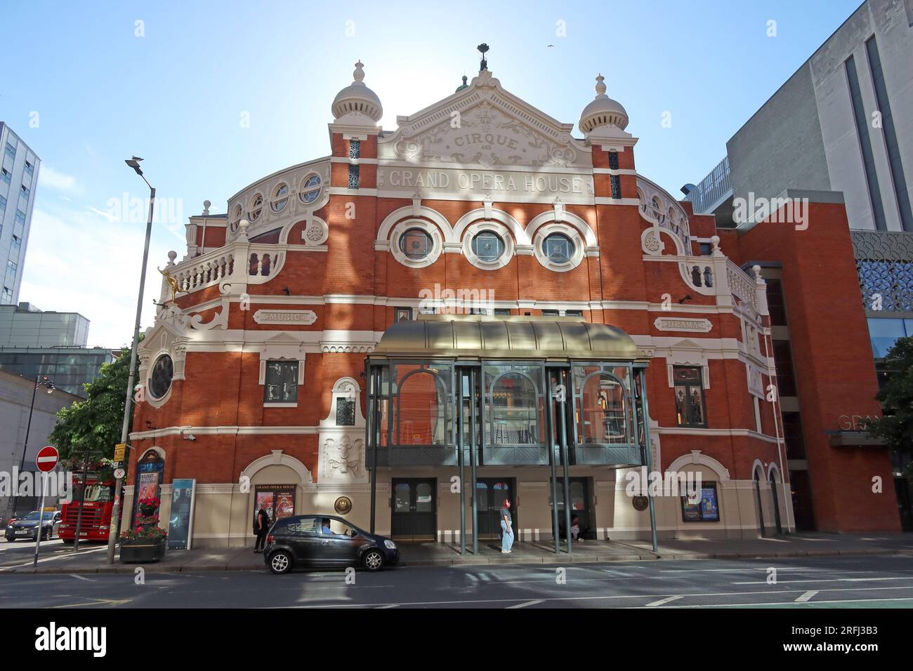 Le Grand Opera House sur Great Victoria Street dans le centre-ville de Belfast, illuminé par la lumière du soleil d'été et la lumière réfléchie, Irlande du Nord Banque D'Images