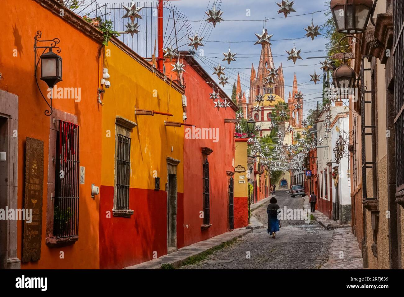 Des étoiles mexicaines en étain se sont accrochées à travers la Calle Aldama pavée avec le clocher de la Parroquia rose de San Miguel Arcangel dominant au-dessus du centre-ville historique de San Miguel de Allende, au Mexique. Banque D'Images