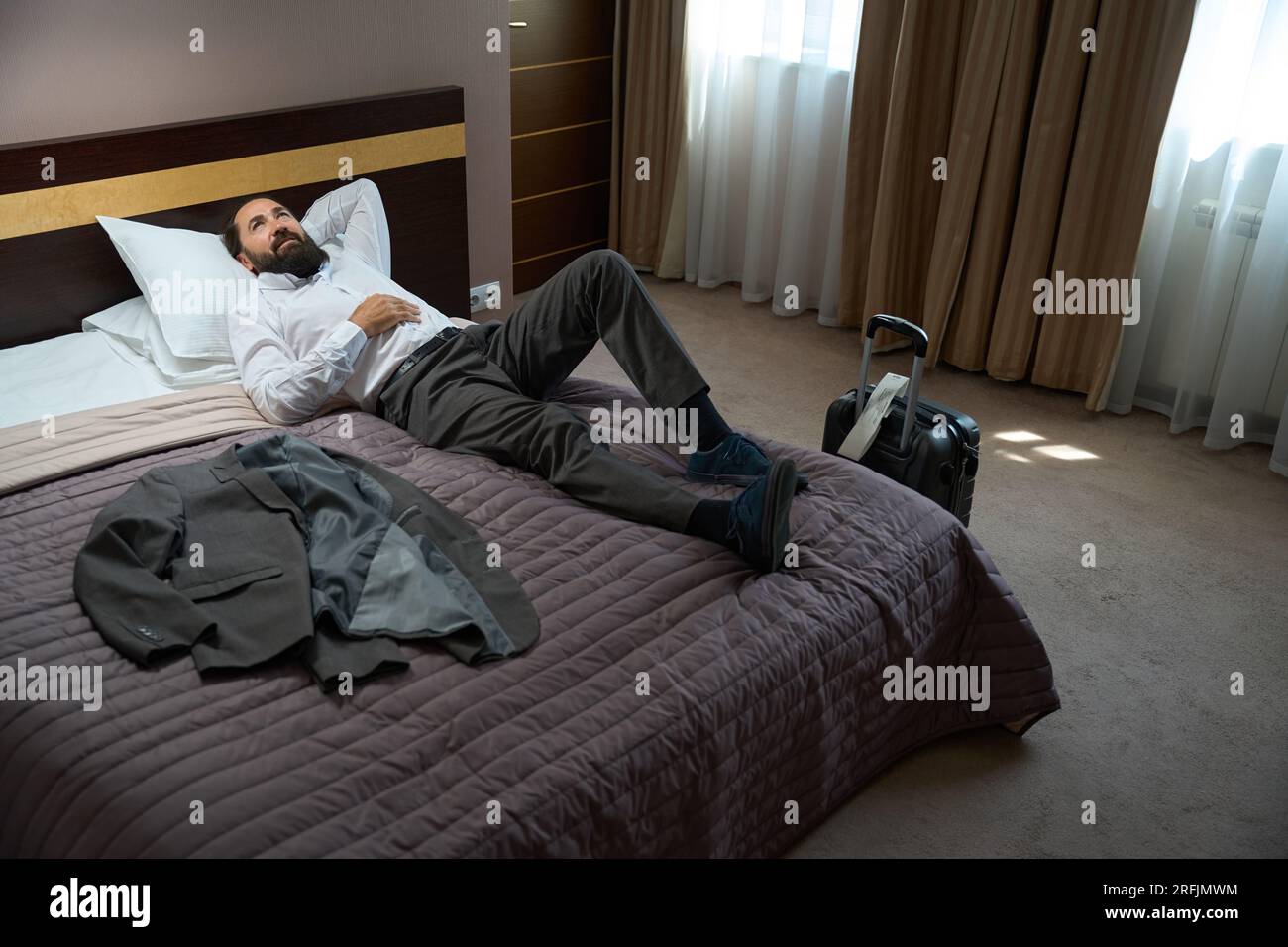 Le voyageur seul s'est allongé pour se reposer sur des oreillers moelleux,  la chambre est propre et confortable Photo Stock - Alamy