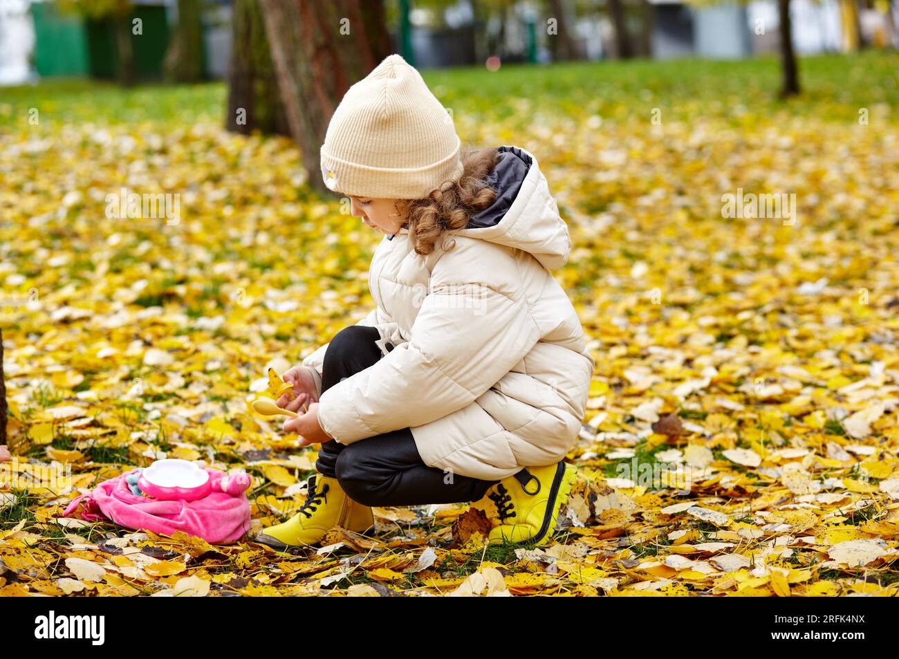 Une petite fille marche dans le parc de la ville d'automne. Petit enfant s'amusant à l'extérieur. Saison d'automne. Enfance Banque D'Images