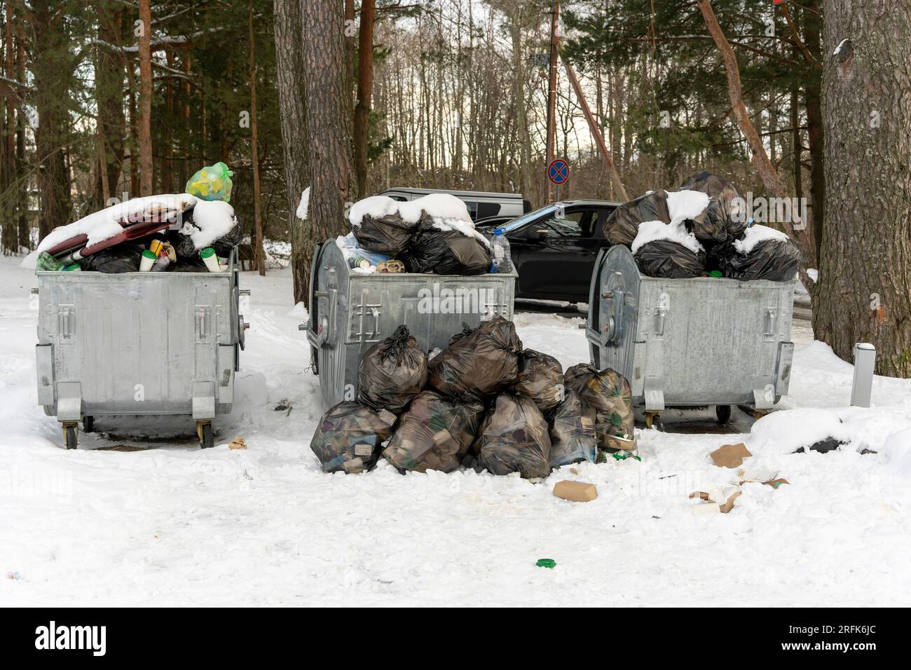 des conteneurs à ordures débordant sur le site autour desquels les ordures et les sacs de déchets sont dispersés. Mauvaise performance des services publics. Banque D'Images