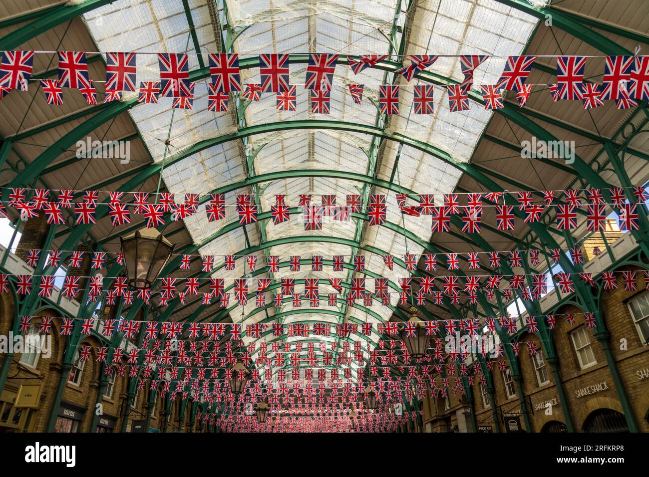 Londres, Angleterre, Royaume-Uni - 7 mai 2023. Des milliers de drapeaux britanniques Union Jack en bandoulière, drapeaux britanniques au marché de Covent Garden pour le couronnement du roi Charles III. Banque D'Images
