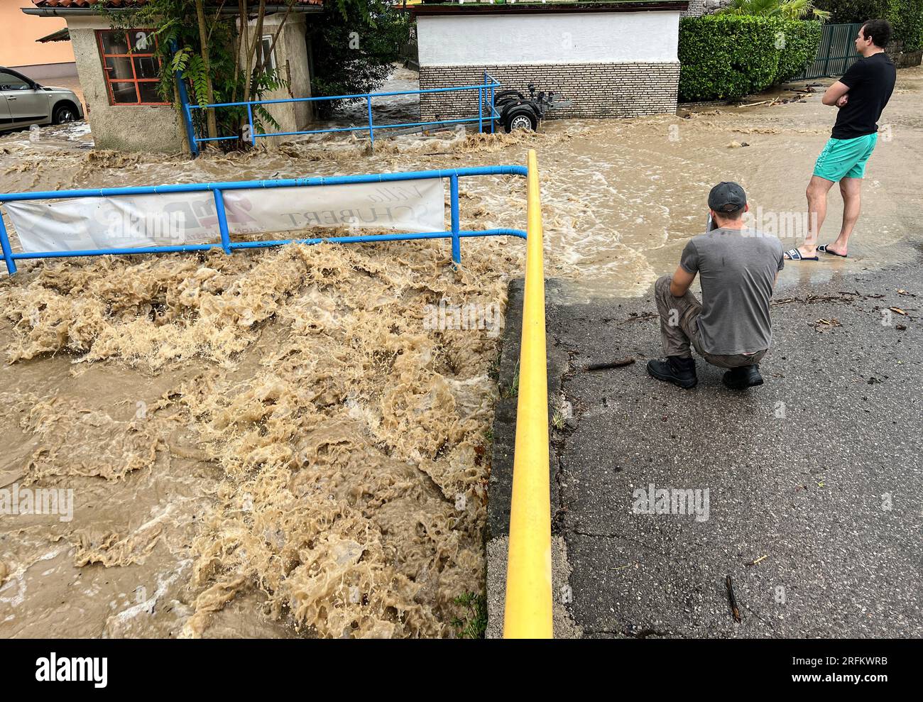 IKA, Croatie. 04 août 2023. Résidents et touristes filment un ruisseau débordant de ses rives à Ika. Des heures de fortes pluies et d'orages ont rendu impraticables de nombreuses routes de la région, populaire auprès des vacanciers. Crédit : Boris Roessler/dpa/Alamy Live News Banque D'Images