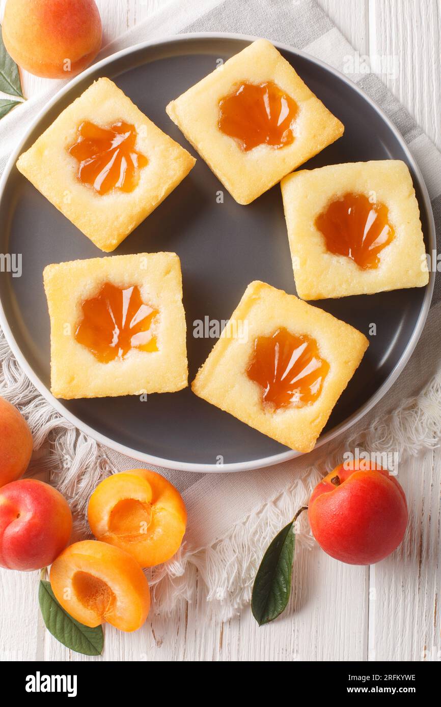 Délicieux gâteau frais farci à l'abricot gros plan sur une assiette sur la table. Vue verticale de dessus Banque D'Images